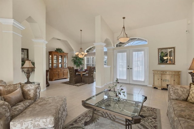 tiled living room with high vaulted ceiling, french doors, and ornate columns