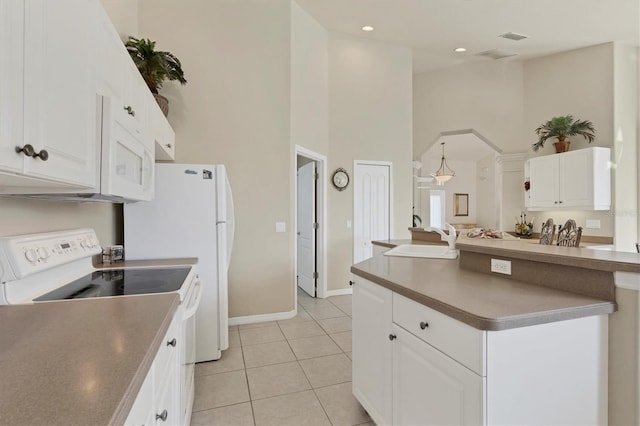 kitchen featuring light tile patterned flooring, a towering ceiling, white cabinetry, sink, and white appliances