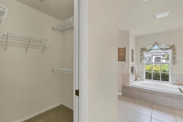 bathroom with tiled bath and tile patterned floors