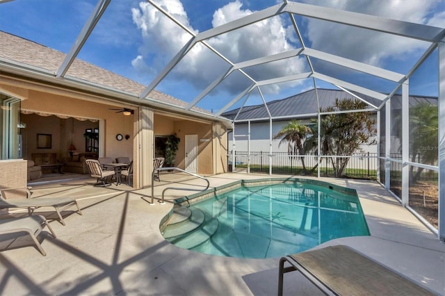 view of pool featuring ceiling fan, glass enclosure, an outdoor hangout area, and a patio