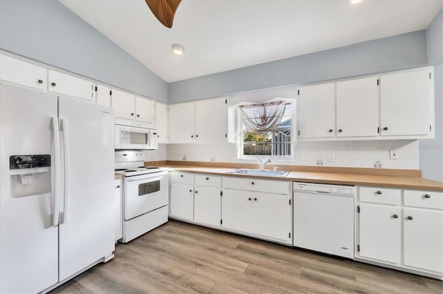 kitchen featuring sink, white appliances, light hardwood / wood-style flooring, and white cabinets