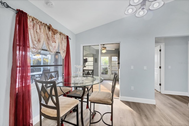 dining space with light hardwood / wood-style floors and vaulted ceiling