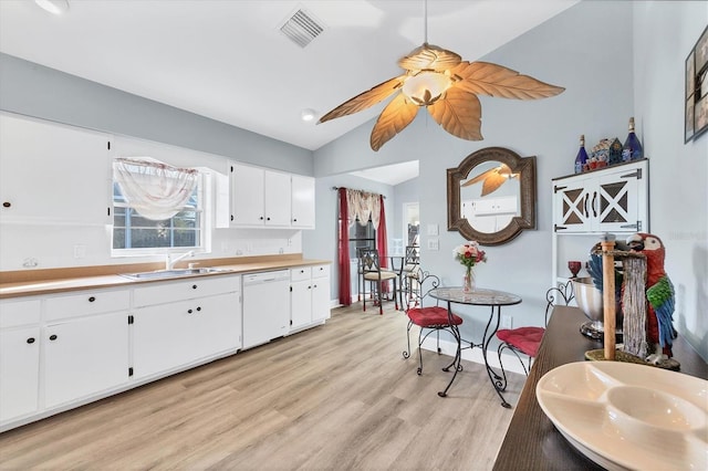 kitchen featuring sink, light hardwood / wood-style flooring, white cabinetry, white dishwasher, and vaulted ceiling