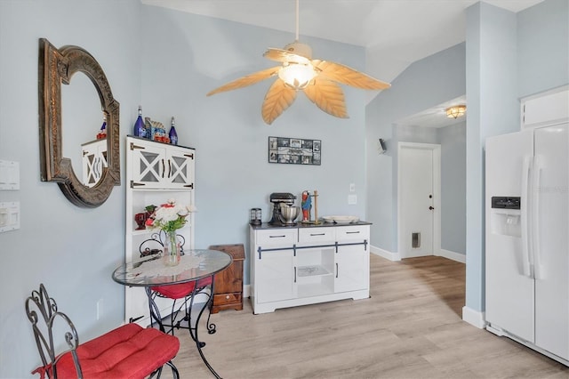 kitchen featuring light hardwood / wood-style flooring, white cabinets, white refrigerator with ice dispenser, and ceiling fan