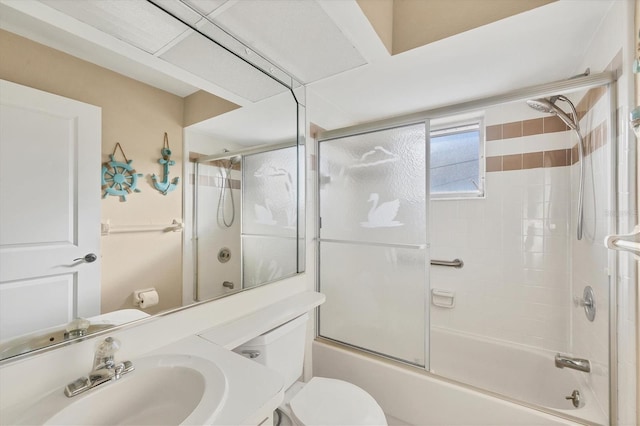 full bathroom featuring vanity, shower / bath combination with glass door, and toilet