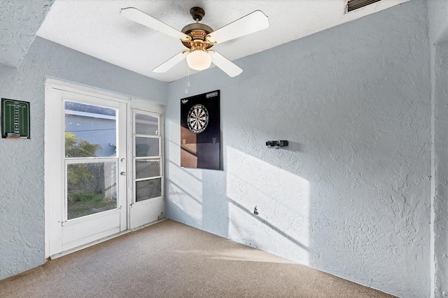 carpeted spare room featuring ceiling fan