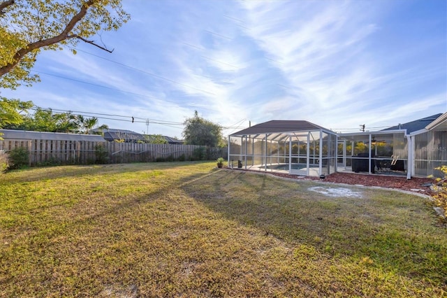 view of yard featuring a fenced in pool and glass enclosure