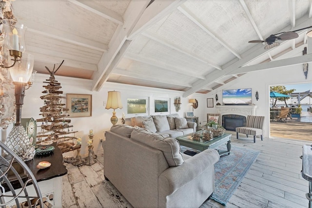 living room with lofted ceiling with beams, ceiling fan, and light hardwood / wood-style floors