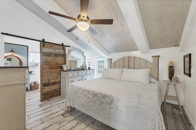 bedroom featuring a barn door, vaulted ceiling with beams, ceiling fan, and light hardwood / wood-style flooring