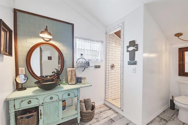 bathroom with walk in shower, lofted ceiling, vanity, and toilet