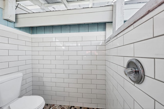 bathroom featuring a tile shower and toilet