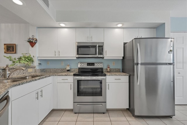 kitchen with white cabinetry, appliances with stainless steel finishes, sink, and light stone counters