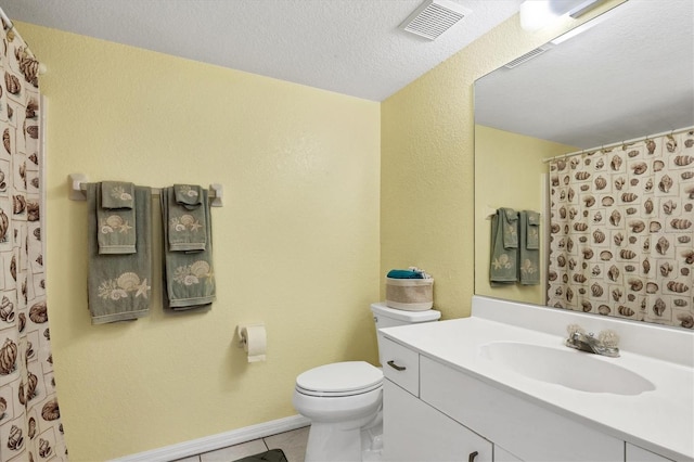 bathroom featuring tile patterned floors, vanity, toilet, and a textured ceiling