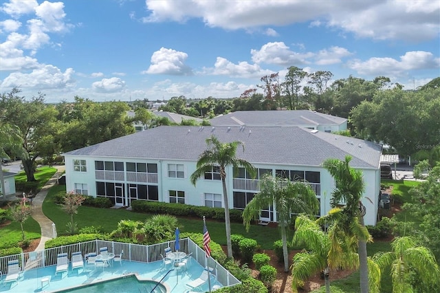 rear view of property featuring a fenced in pool and a patio area