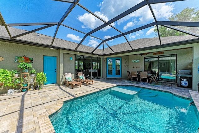 view of swimming pool featuring a patio area, french doors, pool water feature, and glass enclosure