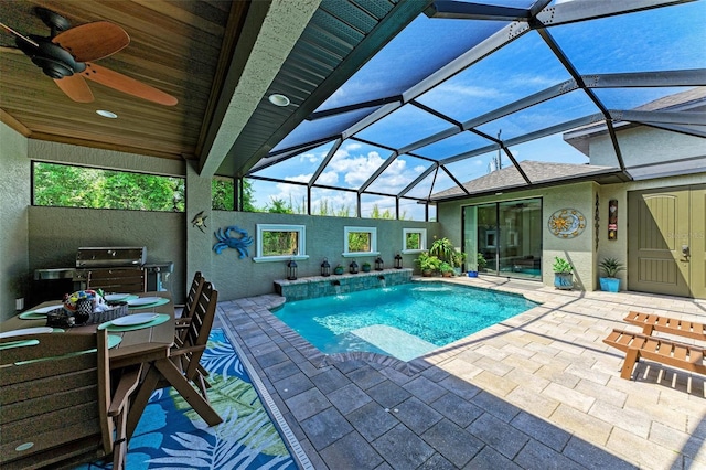 view of swimming pool with pool water feature, a patio area, grilling area, glass enclosure, and ceiling fan