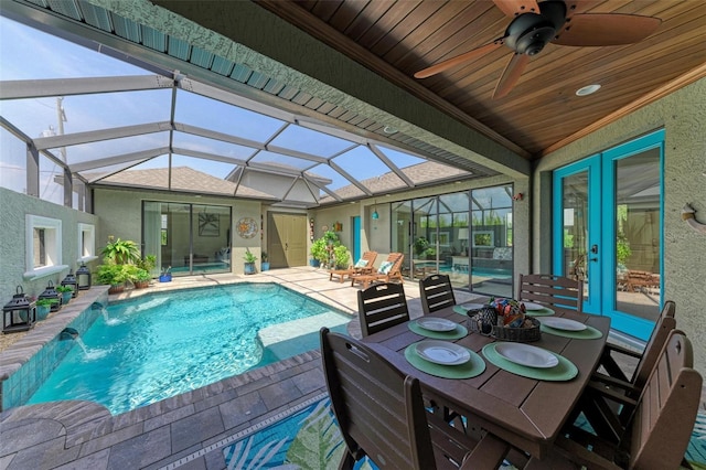 view of pool featuring pool water feature, ceiling fan, a lanai, and a patio area