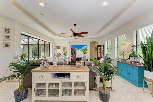 sunroom / solarium featuring a raised ceiling and ceiling fan