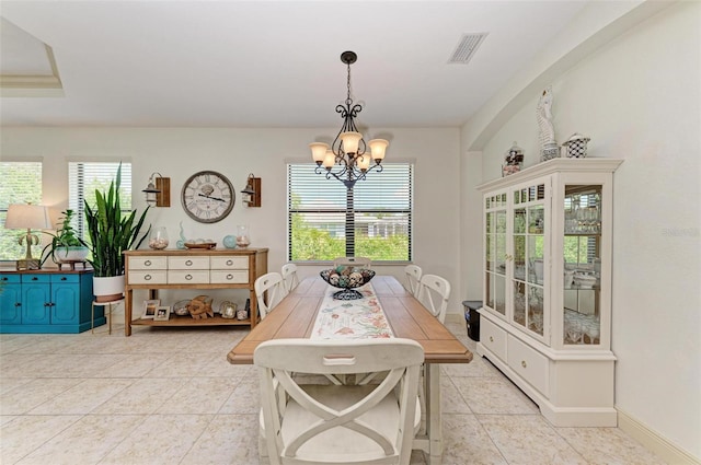 tiled dining space with an inviting chandelier and a healthy amount of sunlight