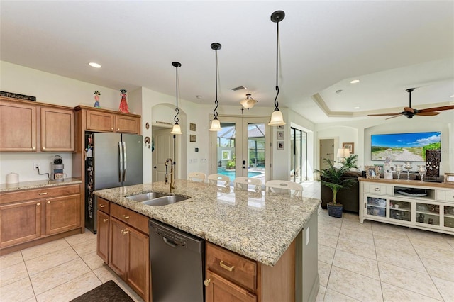 kitchen featuring french doors, sink, hanging light fixtures, a center island with sink, and black dishwasher