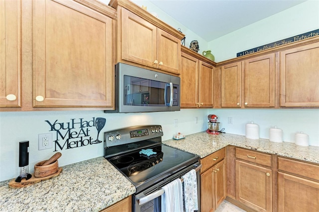 kitchen featuring stainless steel appliances and light stone countertops