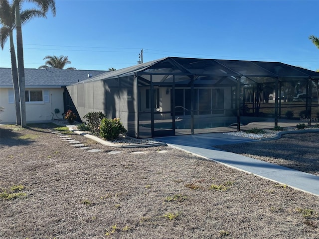 view of front of home featuring glass enclosure, a patio, and stucco siding