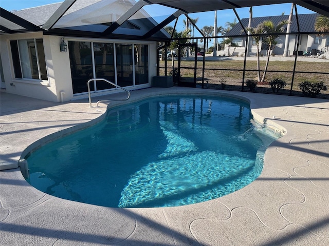 outdoor pool featuring glass enclosure and a patio