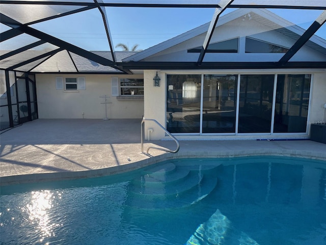 outdoor pool featuring glass enclosure and a patio