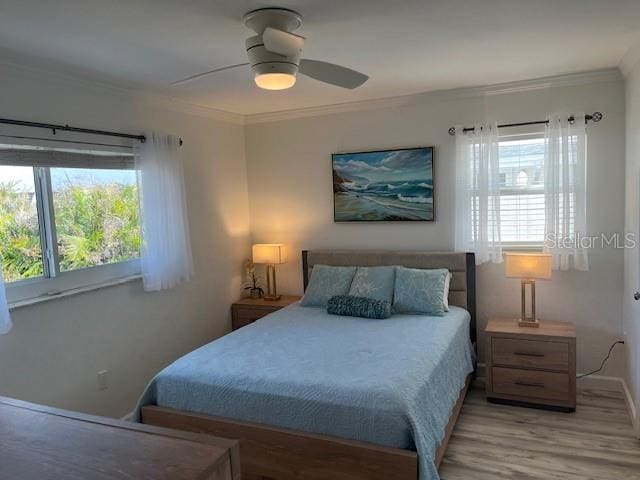 bedroom with light wood finished floors, ornamental molding, and a ceiling fan