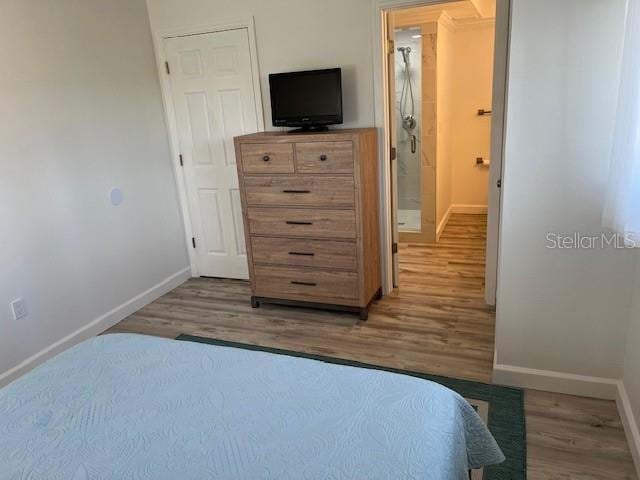 bedroom with baseboards and wood finished floors