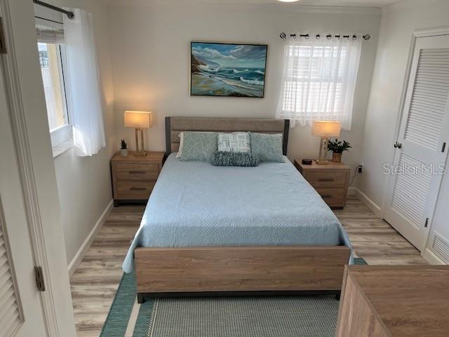 bedroom featuring light wood-style floors and baseboards