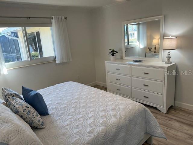 bedroom featuring wood finished floors and baseboards