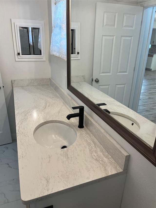 bathroom with marble finish floor and vanity