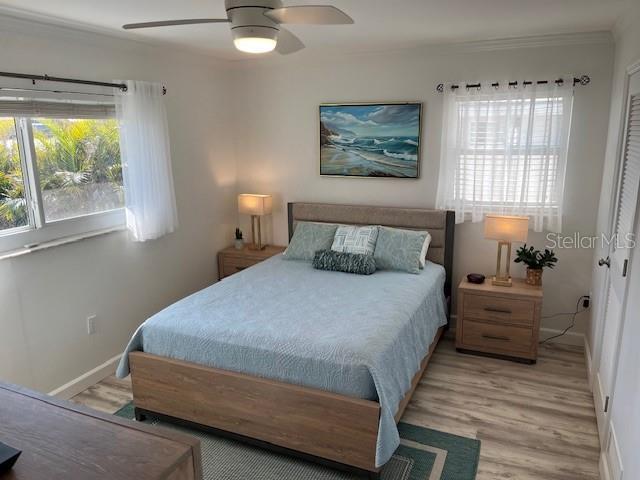 bedroom featuring baseboards, light wood-type flooring, and ceiling fan