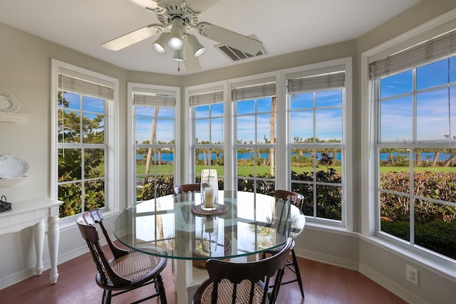 sunroom / solarium with a water view and ceiling fan