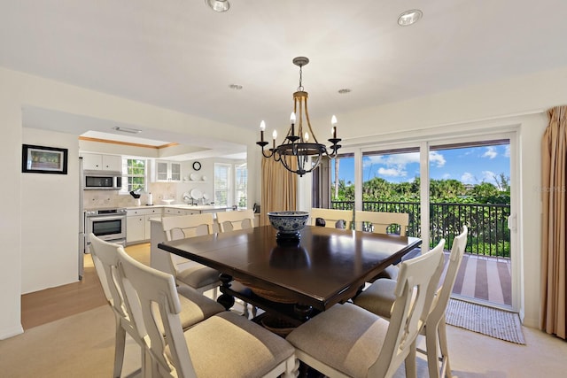 dining area featuring an inviting chandelier and a raised ceiling