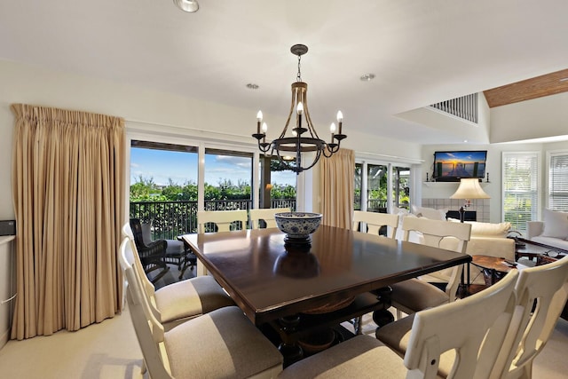 carpeted dining area with a chandelier