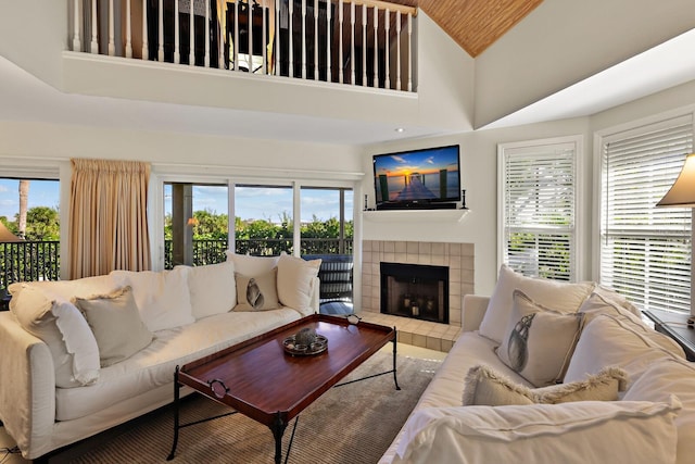 living room with a fireplace, high vaulted ceiling, and a healthy amount of sunlight