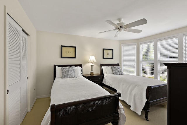 bedroom featuring ceiling fan, light colored carpet, and a closet