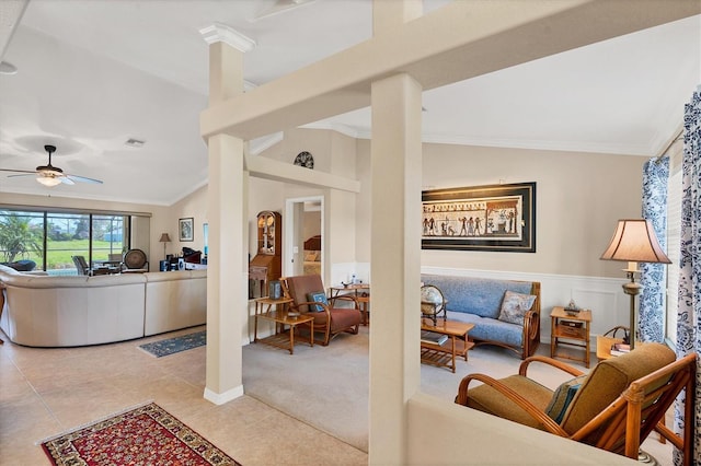 living room featuring lofted ceiling, light tile patterned floors, ceiling fan, decorative columns, and ornamental molding