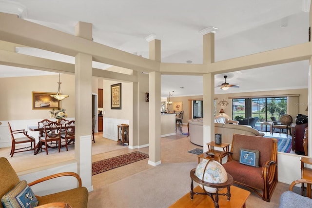 living room featuring lofted ceiling, crown molding, light colored carpet, and ceiling fan