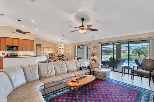 living room featuring lofted ceiling, light tile patterned floors, crown molding, and ceiling fan with notable chandelier