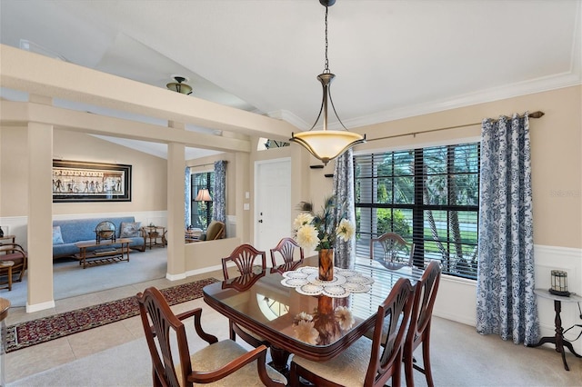 dining room with light tile patterned flooring, lofted ceiling, and crown molding