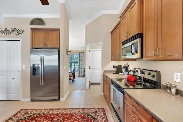 kitchen with crown molding, light tile patterned flooring, and appliances with stainless steel finishes