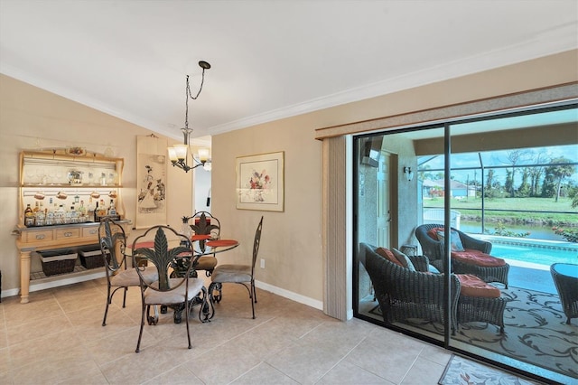 tiled dining room featuring lofted ceiling, crown molding, and a chandelier