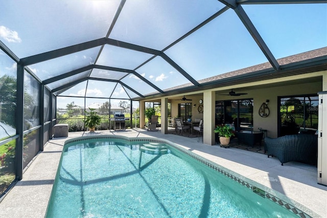 view of swimming pool featuring ceiling fan, glass enclosure, and a patio area