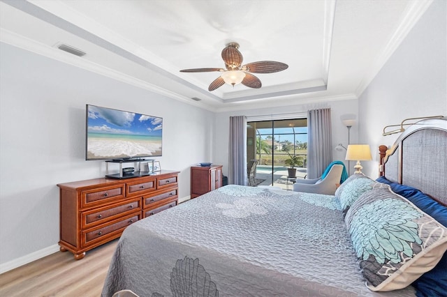 39 Tournament Rd, Rotonda West, FL 33947 - bedroom featuring light wood-type flooring, a raised ceiling, access to outside, baseboards, and a ceiling fan