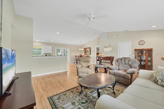 living room with vaulted ceiling, ceiling fan, and light hardwood / wood-style flooring