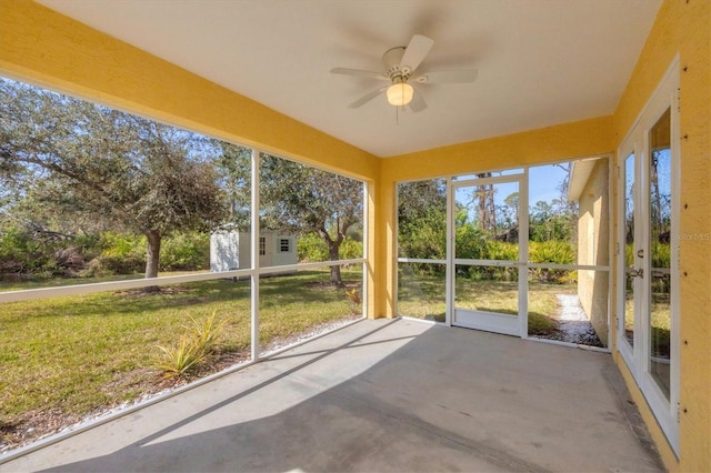 unfurnished sunroom with ceiling fan