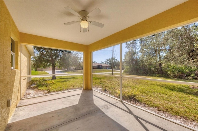 unfurnished sunroom featuring ceiling fan